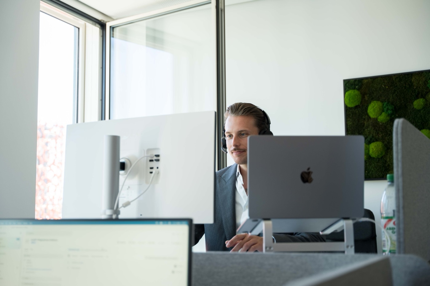 Mitarbeiter mit Headset am Schreibtisch